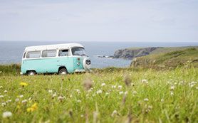 camper van by the sea with grass and cliffs