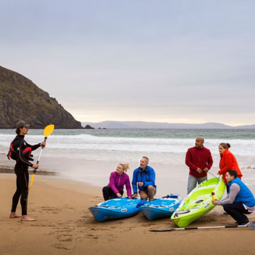 Group on the beach in Dingle Kerry learning to Kayak.