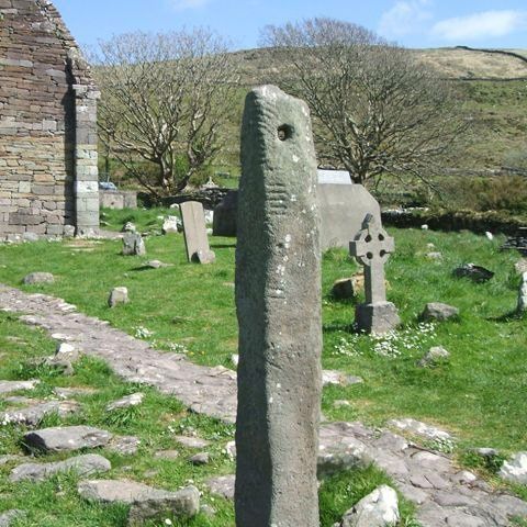 ogham stone showing cut notches and a hole in front 