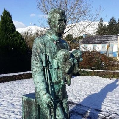 Statue of Tom Crean holding puppies in small park across from South Pole inn Annascaul Dingle Peninsula Ireland