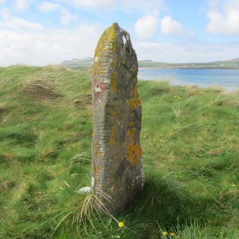 Ogham Stone standing near shoreline at Smerwick harbour Dingle Peninsula